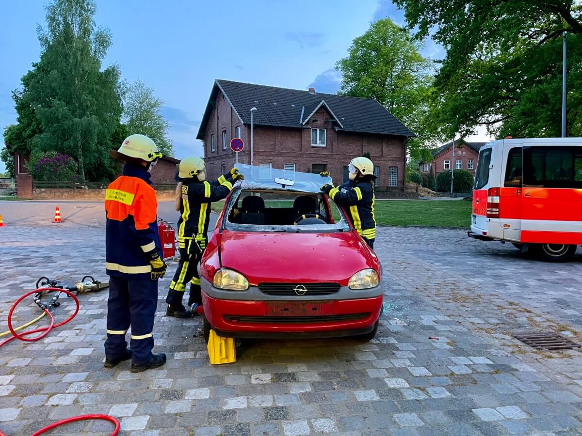 Feuerwehrfrauen entfernen die Windschutzscheibe eines Opel Corsa bei einer Übung in Ahrensburg Ahrensfelde