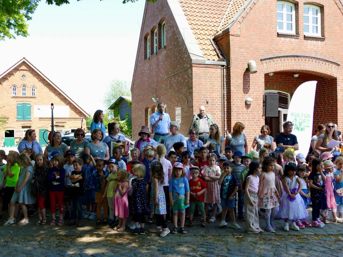 Ahrensburgs Bürgermeister Eckart Boege (Mitte hinten) eröffnet Kultur4Ort in Ahrensfelde mit den Kindern der KiTA Schäferweg – Foto: Nicole Theinert