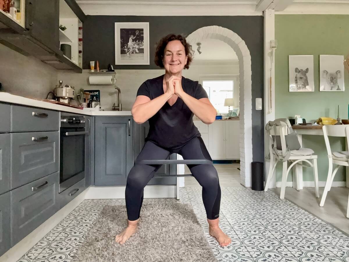 Eine Frau macht Kniebeugen mit Gymnastikband