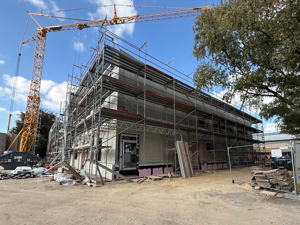 Baustelle einer Schule. Gebäude mit Gerüst, daneben ein Kran. Grundschule am Hagen, Ahrensburg.
