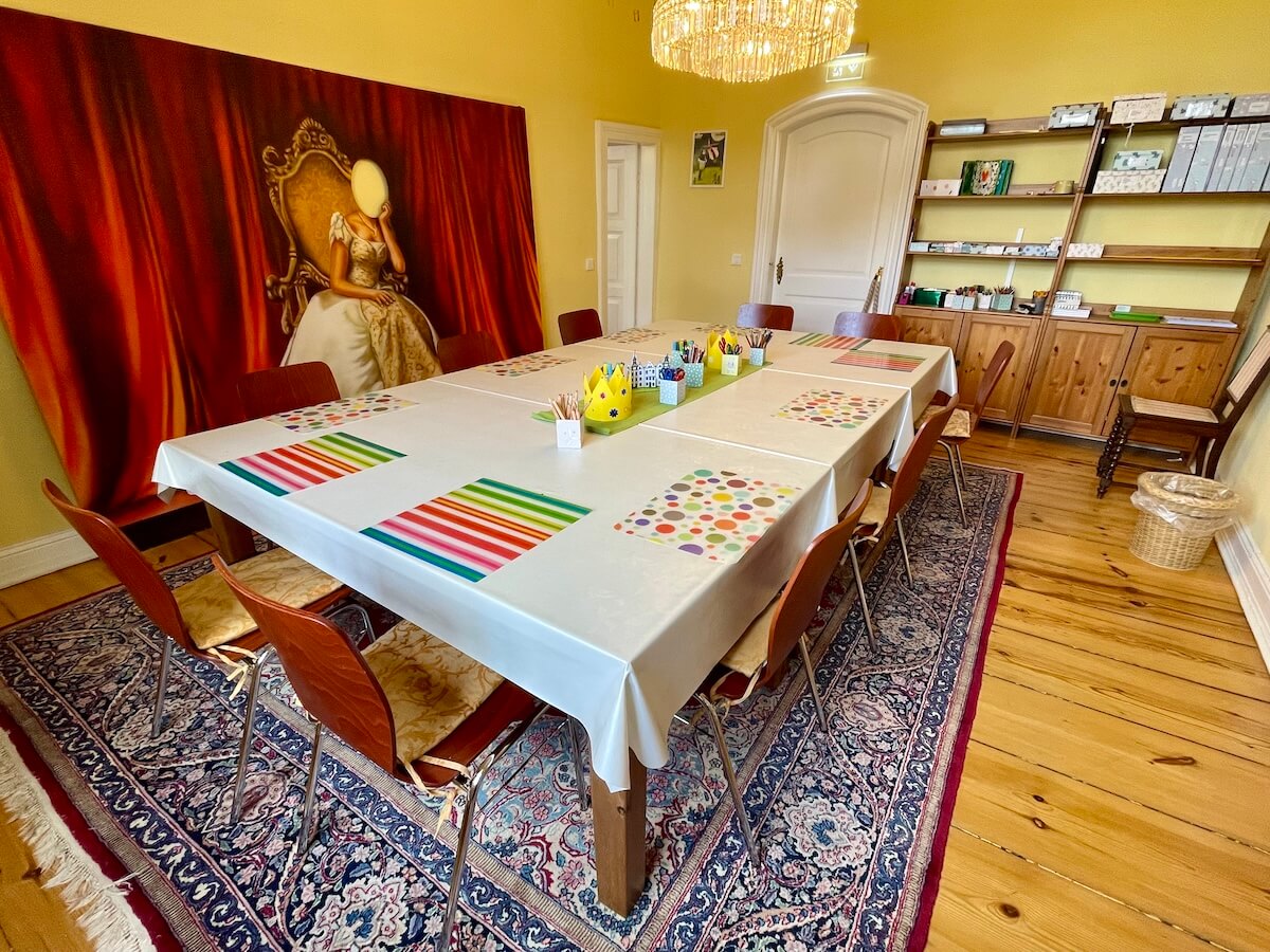 Ein großer Tisch mit Bastelutensilien in einem prunkvollen Raum