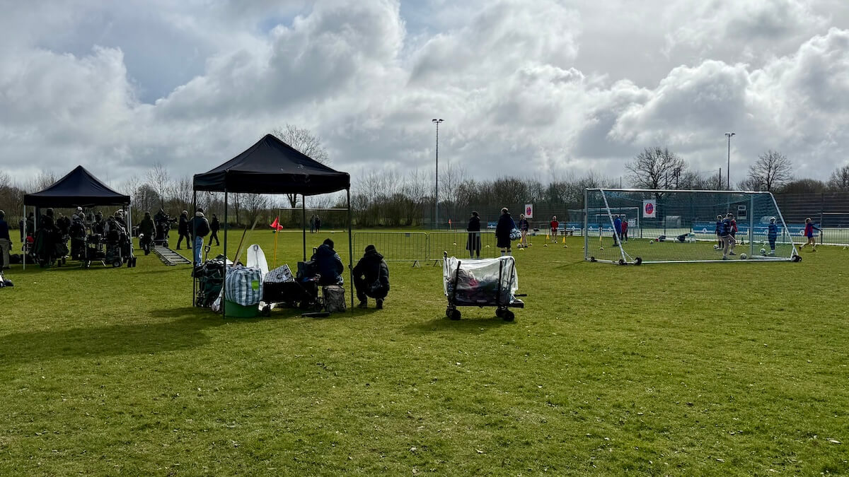Fußballplatz, Pavillions, im Hintergrund Spielerinnen
