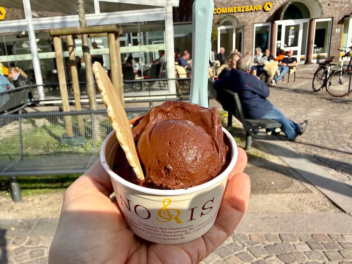 Eine Hand hält einen Becher mit Schokoladeneis