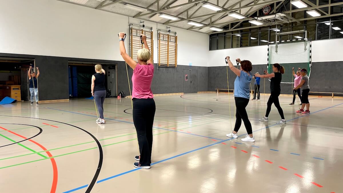 Mehrere Frauen machen Gymnastik in einer Sporthalle
