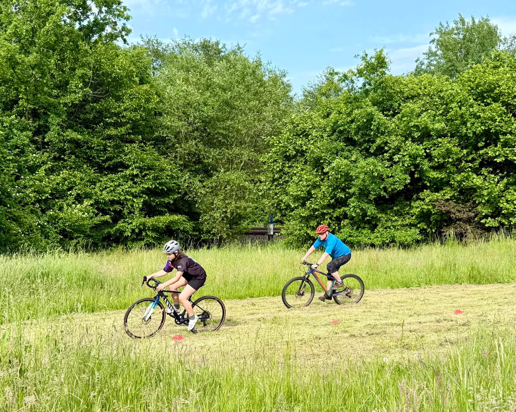 Zwei Menschen auf Crossrädern auf einer Wiese