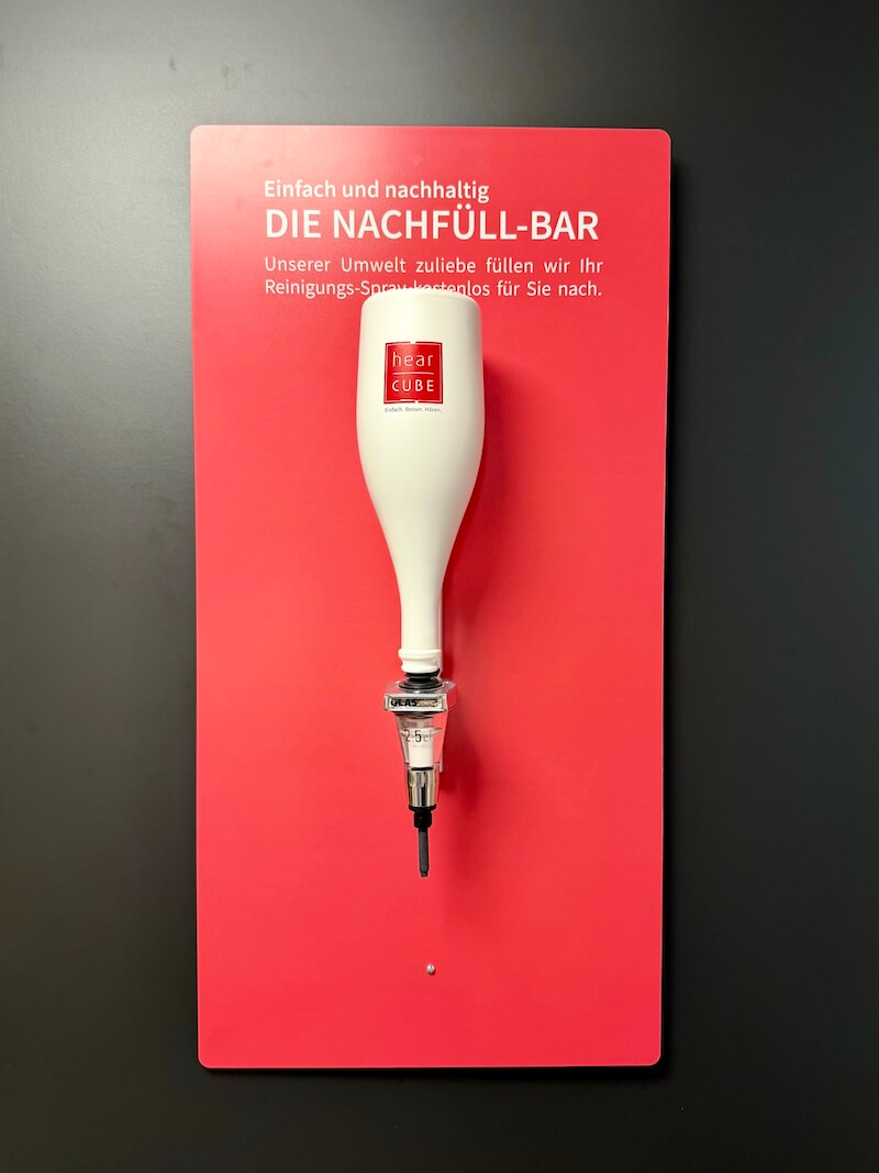 Nachfüllstation für ein Reinigungsmittel für Brillen, Flasche an der Wand