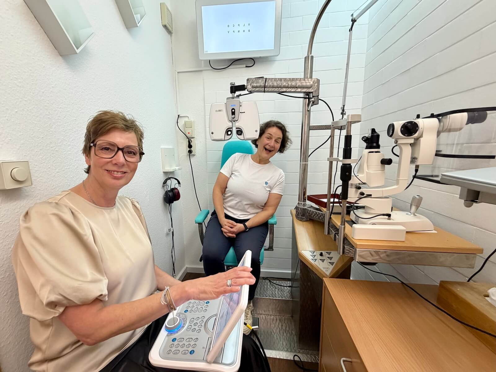 Zwei Frauen, eine Augenoptikerin und eine Kundin beim Sehtest