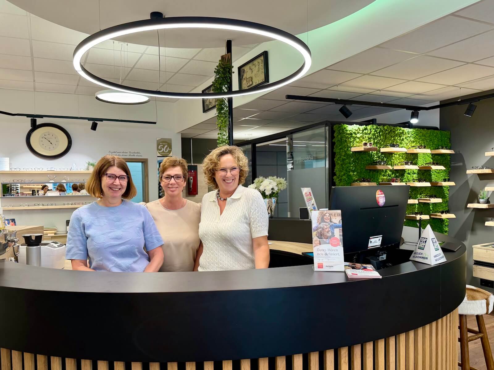 Drei Frauen am Empfangstresen eines Brillenfachgeschäftes