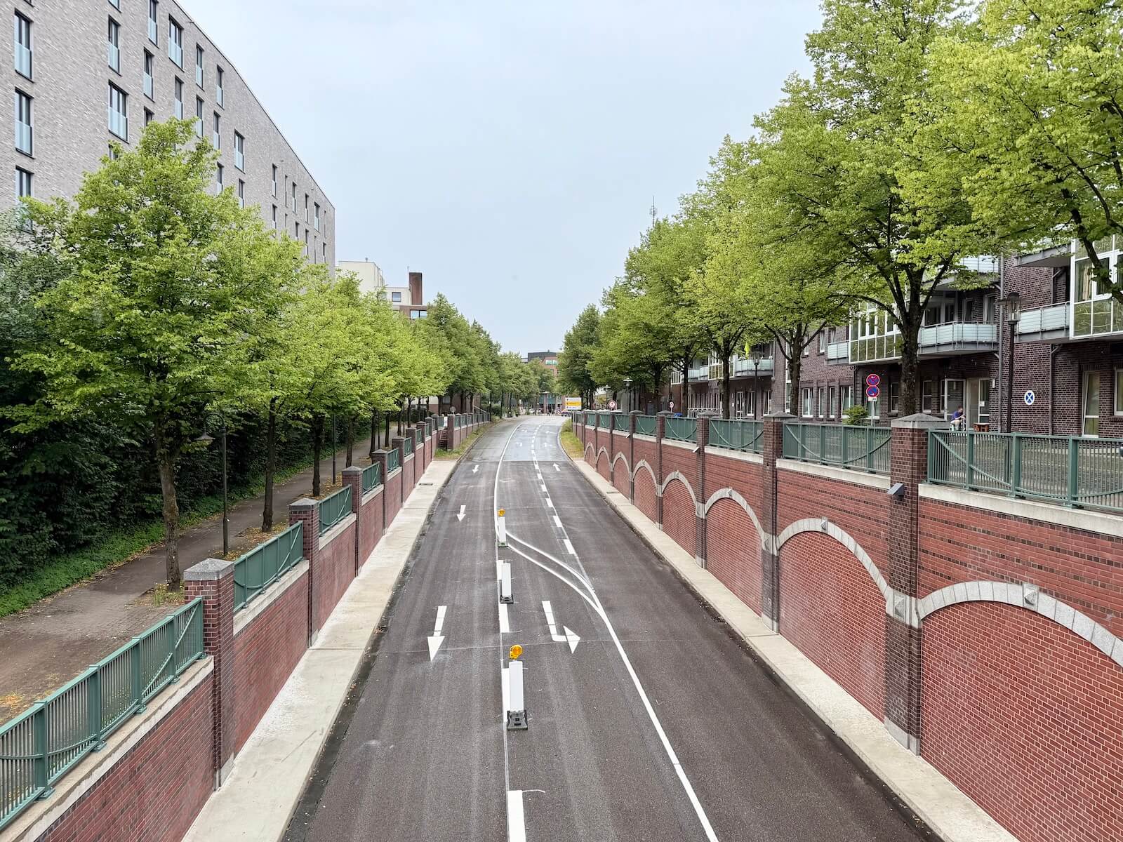 Straße in Ahrensburg in einem Trog, also mit Wänden rechts und Links, daneben ein Hochhaus